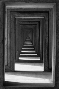 Visuelle Darstellung einer Echokammer: Eine endlose Flucht aus Betonrahmen, die den Tunnelblick und die ständige Selbstbestätigung im Vertrieb symbolisiert.