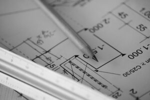 Bauplan mit Bleistift als Symbol für interne Entscheidungsprüfung und die Statik strategischer Entscheidungen