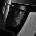 Mann liest einen Text und sieht dabei sein eigenes Spiegelbild auf einem Bildschirm – Symbol für vorschnelle Urteile über KI-generierte Texte.