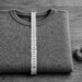 Schwarz-Weiss-Aufnahme eines gefalteten Pullovers, der mit einem Massband auf etwa 30 Zentimeter gemessen wird